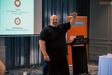 Kristian Livolsi On Stage at Momentum Growth School - Group Business Coaching Program